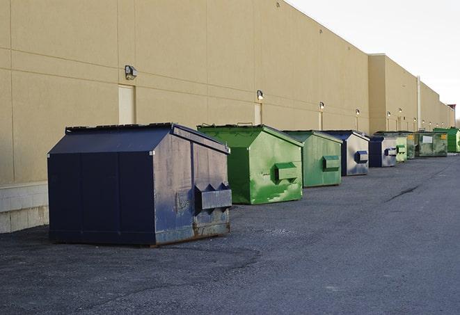 a construction worker moves construction materials near a dumpster in Elgin